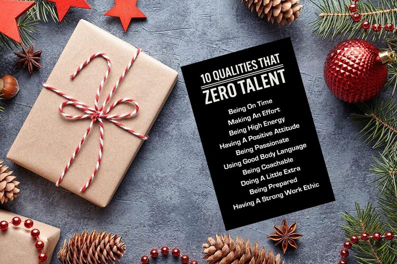 May include: A festive holiday scene with a wrapped gift, pine cones, and ornaments. The gift is wrapped in brown paper and tied with red and white twine. A black card lists "10 Qualities That Zero Talent" in white text.