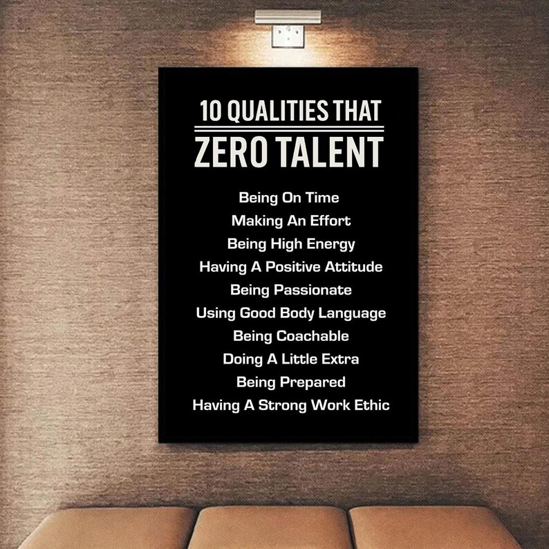 May include: A black rectangular wall art piece with white text. The text reads "10 QUALITIES THAT ZERO TALENT" followed by a list of ten qualities. The artwork is mounted on a textured wall.