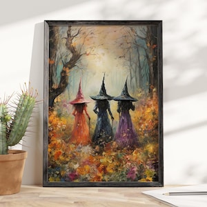 May include: A framed wall art print depicting three figures wearing pointed hats and long dresses in orange, dark blue, and purple, standing in a forest with autumn foliage. The scene features trees and fallen leaves in warm, vibrant colors.