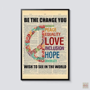 May include: A framed wall art print featuring a dictionary page background with the text BE THE CHANGE YOU WISH TO SEE IN THE WORLD. A large, colourful, patterned peace sign sits on the left, with words KINDNESS, PEACE, EQUALITY, LOVE, INCLUSION, HOPE, DIVERSITY stacked on the right.