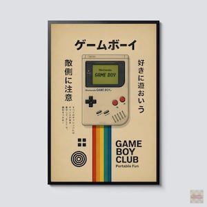 Op de afbeelding: Een ingelijste poster met een beige achtergrond en een centrale illustratie van een grijze draagbare spelcomputer. De tekst bevat Game Boy, Game Boy Club en Japanse tekens. Een verticale regenboogstreep loopt naar beneden vanaf de console.