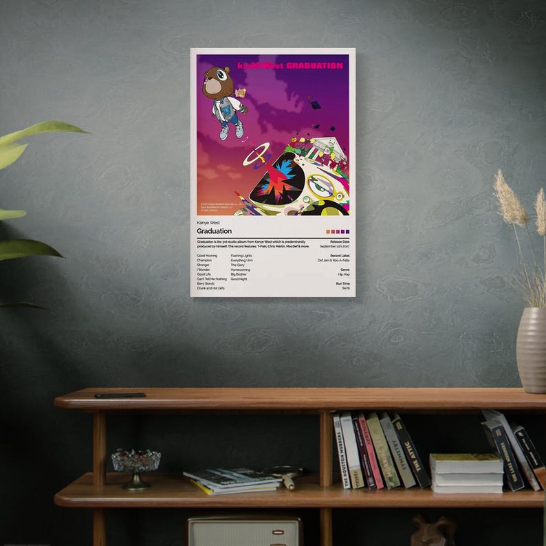 May include: A poster featuring the album art for Kanye West's "Graduation." The artwork depicts a cartoon bear in a varsity jacket floating above a car with a colorful design against a purple and orange sky. The album title is at the top.
