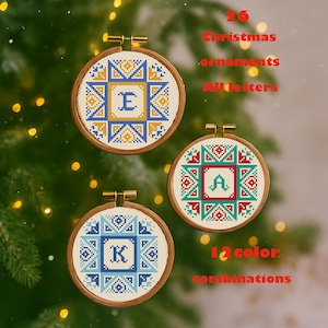 May include: Three embroidered Christmas ornaments with wooden hoops. Each features a letter in the center, surrounded by geometric patterns in blue, yellow, and red. The text reads "26 Christmas ornaments All letters 12 color combinations."