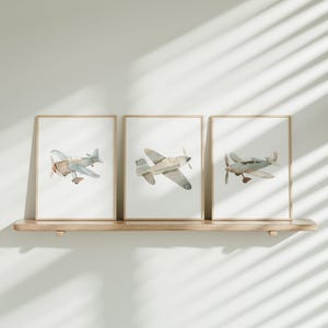 three framed photos of airplanes hanging on a wall