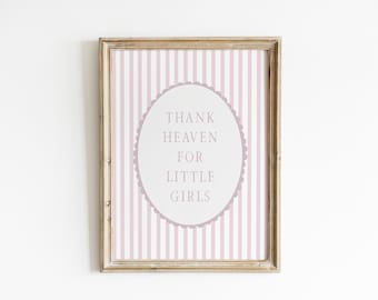 May include: Framed print with a light pink and white striped background. The print features an oval shape with the text "THANK HEAVEN FOR LITTLE GIRLS" in a soft gray color. The frame is a light brown color.