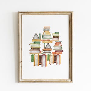 A framed watercolor painting depicting a stack of colorful books.
