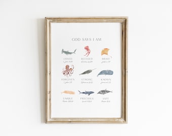 May include: Framed art print with a light wood frame. The print features watercolor illustrations of sea creatures and the words "GOD SAYS I AM" above the illustrations. Each illustration has a corresponding word such as "LOVED" and "BLESSED".
