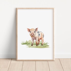 May include: A watercolor painting of a pink and white piglet standing in a patch of green grass. The piglet has black spots and is looking directly at the viewer.