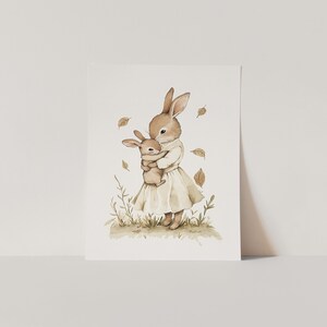 a card with a picture of a rabbit holding a baby