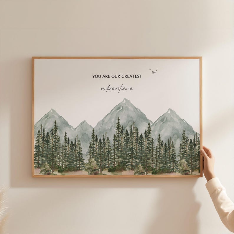 a person holding up a picture of a mountain
