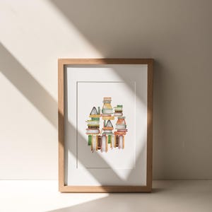 A framed artwork depicting a colorful abstract design is displayed on a white wall, with sunlight casting shadows on the wall.