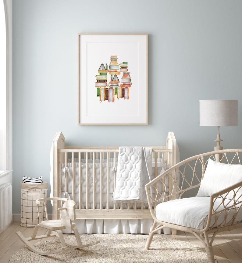 A nursery room with a crib, rocking chair, and a framed print of a colorful building design on the wall.