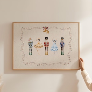 May include: A framed print featuring watercolor illustrations of five Nutcracker characters. The characters include a mouse king, a ballerina, two toy soldiers, and a ballerina. The print is framed in a light brown wooden frame.