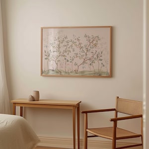 a serene and cozy bedroom scene, featuring a wooden bed frame, a small wooden table, and a woven chair. Above the bed, there is a framed picture of a tree with a pink and green background, adding a touch of nature to the room.