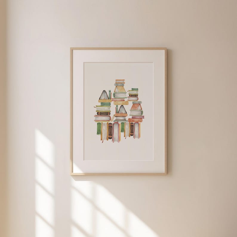 a framed artwork hanging on a wall, depicting a stack of books arranged in a visually appealing manner.