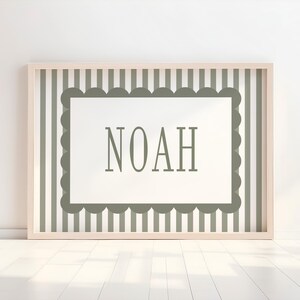 A framed picture with the word "NOAH" displayed on it, set against a background of vertical stripes.
