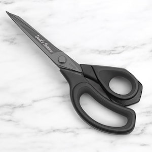May include: Black scissors with the text "David's Scissors" on the blade. The scissors have large, ergonomic handles and a pivot point with a button. The brand name "iringo" is also visible.