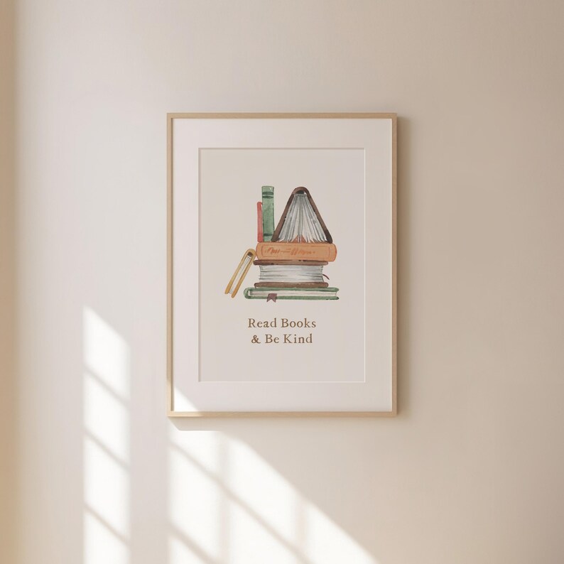 a framed print with a stack of books and the text "Read Books & Be Kind" written below it.