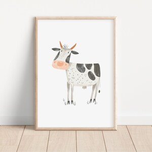 May include: A watercolor illustration of a black and white cow with orange horns and a pink nose. The cow is standing on a green field.