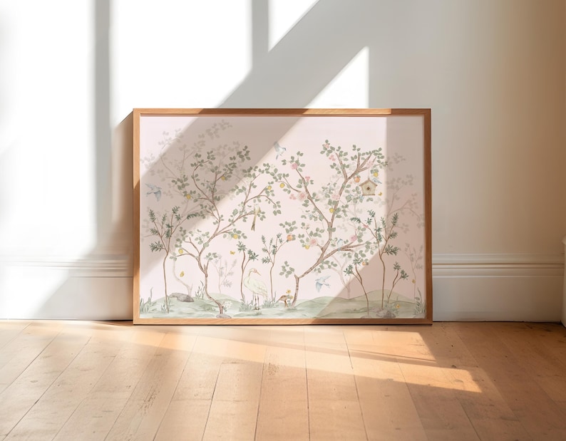 A large framed painting depicting a serene landscape with trees, birds, and a pond is displayed on a wooden floor against a white wall.