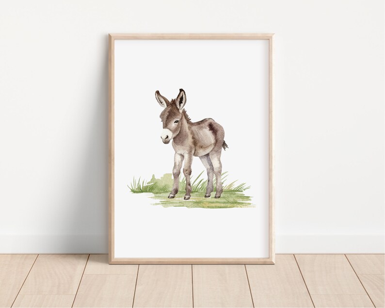 May include: A watercolor painting of a brown and white donkey standing on a green grassy patch. The donkey is facing the left side of the image and has its head tilted down.
