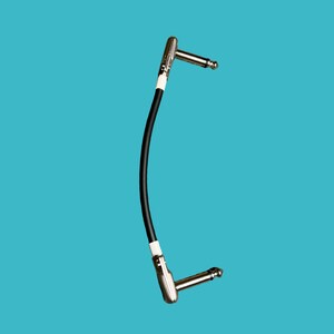 May include: A black guitar cable with two right-angle 1/4 inch plugs.
