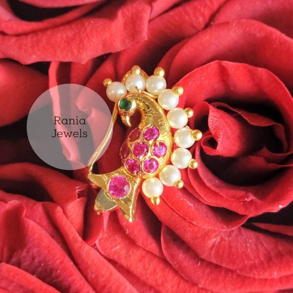 Luxurious nose pin peacock motif Gold plated with ruby red stones, this is a faux nose pin and does not need piercing.
