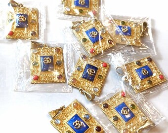 Puede incluir: Ocho colgantes de oro con una piedra azul y un símbolo Om de oro. Cada colgante está rodeado de piedras más pequeñas de varios colores, incluidos rojo, verde y blanco.