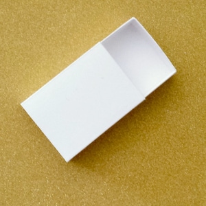 May include: A white cardboard box with a sliding lid. The box is open and the lid is partially pulled back.