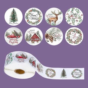 May include: Roll of 1.5 inch round Christmas stickers with various designs including a red truck, a cabin, a pine tree, a deer, and a wreath. The stickers have watercolor-style illustrations and festive text like "Merry Christmas" and "Happy Holidays".