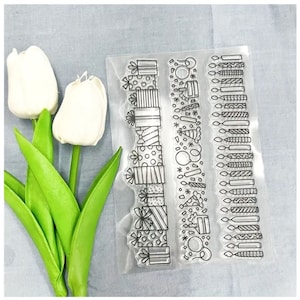 May include: Three clear plastic sheets with black line drawings of birthday party decorations. The first sheet has a repeating pattern of gift boxes with bows. The second sheet has a repeating pattern of party hats, balloons, and candles. The third sheet has a repeating pattern of candles.