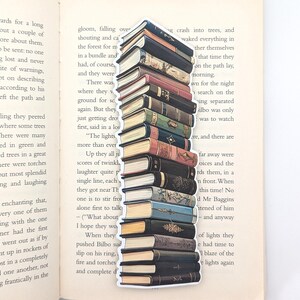 May include: A stack of vintage books with colorful spines and gold lettering. The books are arranged vertically, creating a tall tower. The bookmark is a great way to keep your place in your favorite book.