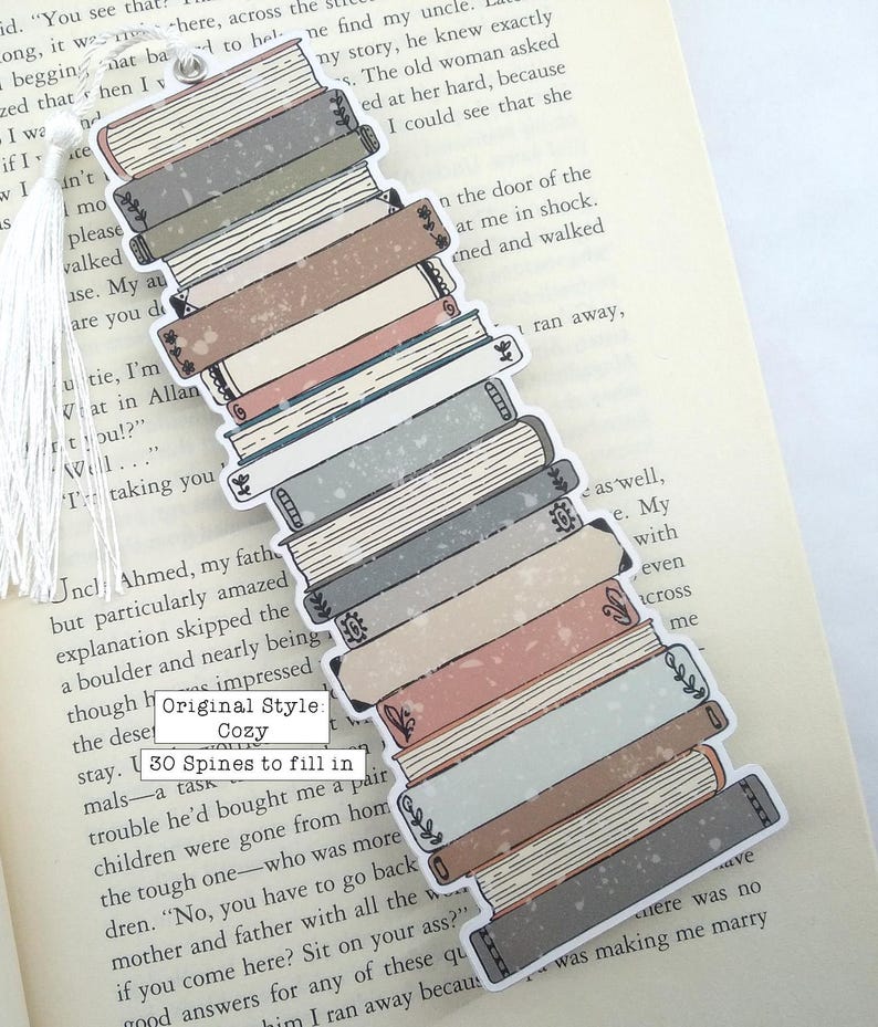 Puede incluir: Una pila de 30 lomos de libros en varios tonos de gris, azul, rosa y marr&oacute;n. Las lomos est&aacute;n decoradas con dise&ntilde;os florales y un aspecto desgastado y vintage. El marcap&aacute;ginas est&aacute; etiquetado como "Estilo original: Acogedor" y "30 lomos para rellenar".