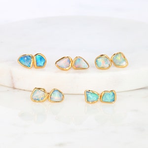 May include: Set of six gold-plated opal earrings. Each earring features two irregularly shaped opals with a light blue and white iridescent sheen.
