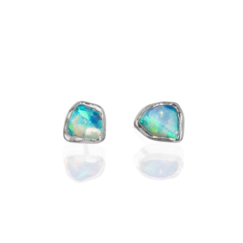 May include: A pair of silver earrings with a blue and green opal stone set in each earring.