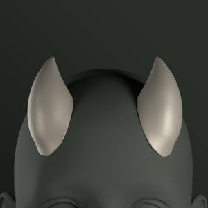 Puede incluir: Primer plano de una cabeza gris renderizada en 3D con dos pequeños cuernos puntiagudos de color gris claro en la parte superior.