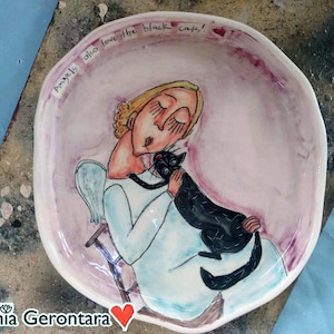 Uniqe ceramic art on a plate, portraying an angel holding a black cat - perfect gift for black cat lovers!