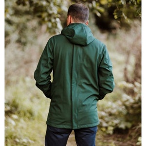 Puede incluir: Una chaqueta verde oscuro con capucha y cierre de cremallera. La chaqueta est&aacute; hecha de un material suave y resistente al agua.