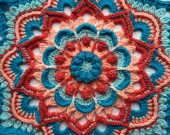 May include: A handmade, circular crochet doily in a vibrant floral pattern. The design features concentric rings of teal, coral, and peach, with a central teal flower. The intricate openwork creates a delicate, textured appearance.