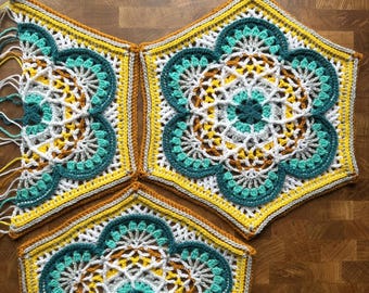 May include: Handmade crochet top in a floral design. The top features a combination of yellow, teal, white, and brown yarn. The crochet work is intricate, with a geometric pattern. The top is shown in three separate pieces, ready to be assembled.