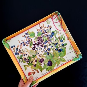 Peut inclure: Plateau de service rectangulaire avec un motif botanique de myrtilles, de mûres et de feuilles. Le plateau a une bordure jaune avec un motif de ruban rose. Le texte "Vaccinium Myrtillus" et "Ribes Nigrum" est visible.