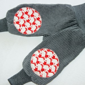 Peut inclure: Pantalon en velours côtelé gris avec des empiècements en tissu à motifs rouge et blanc sur les genoux.