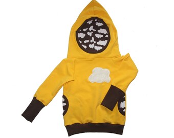 Op de afbeelding: Een geel hooded sweatshirt met bruine bies en witte wolk applicaties. De capuchon is gevoerd met bruin stof en heeft witte wolk applicaties.