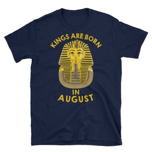May include: Navy blue t-shirt with a gold pharaoh illustration and the text "Kings Are Born In August".