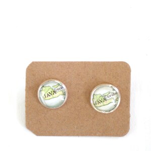 Op de afbeelding: Een paar zilveren oorbelletjes met een kaart van Java, Indonesië, gedrukt op de voorkant. De kaart toont de steden Surabaya en Surabaja.