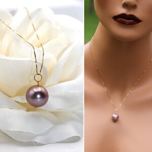 May include: A delicate gold chain necklace with a single, large, round, mauve-colored pearl pendant.