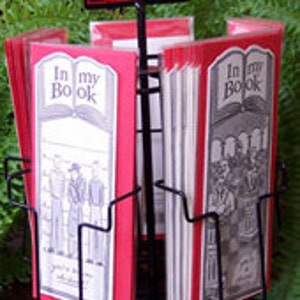 May include: A black metal display stand with red and white bookmarks featuring the text "In my Book" and illustrations of people.