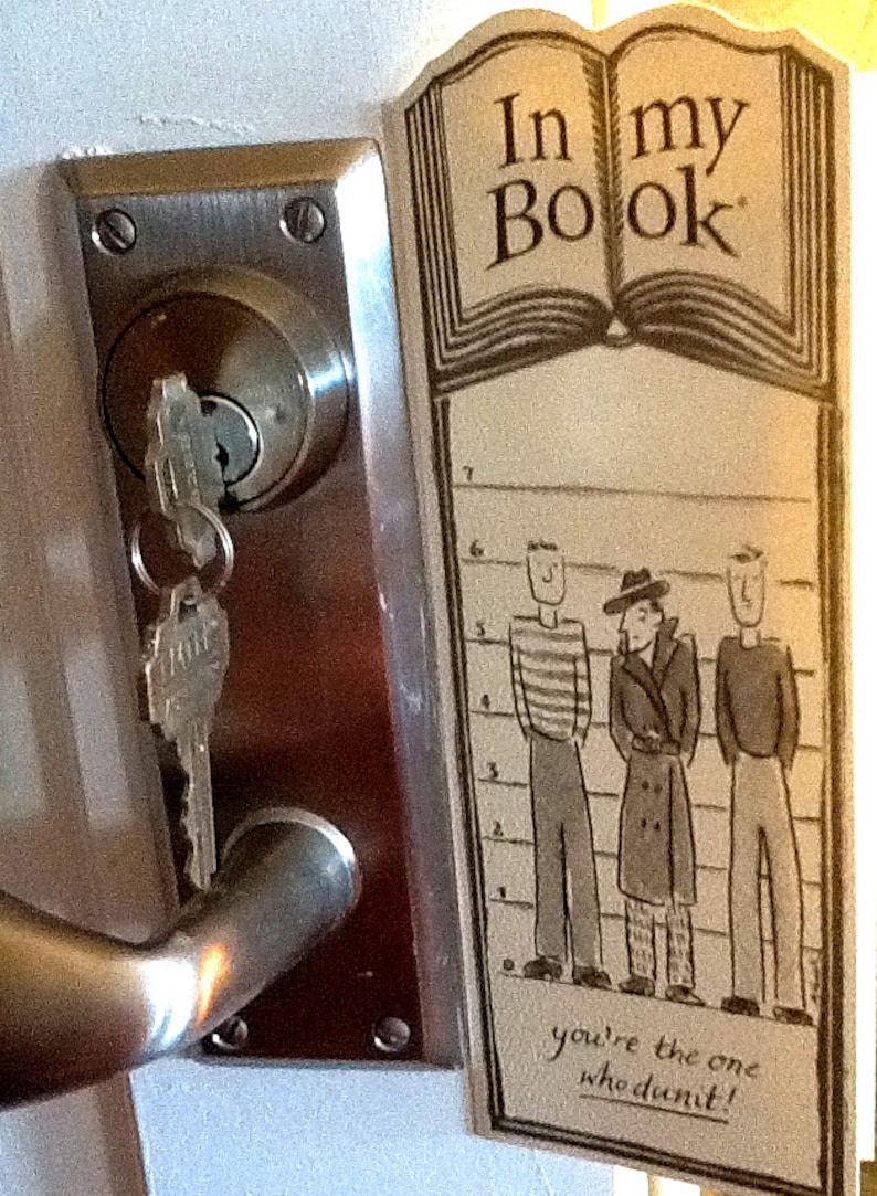 May include: A brown and white sign with the text "In my Book" and a drawing of a book. The sign also has a line-up of three cartoon characters with the text "you're the one who didn't!" at the bottom.