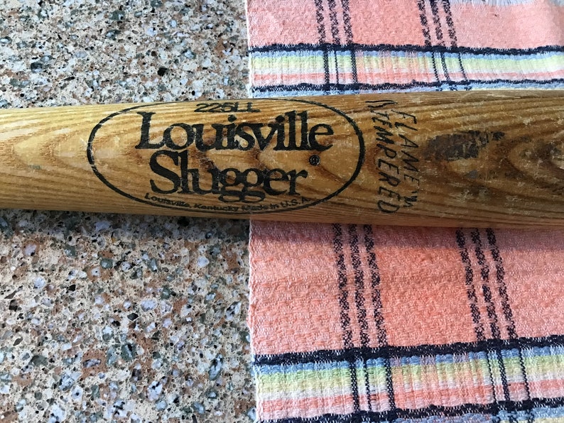 Pu&ograve; includere: Una mazza da baseball in legno Louisville Slugger con lettere nere che recitano "Louisville Slugger" e "25U" con un ovale nero attorno al testo. La mazza ha anche lettere nere che recitano "Flame Tempered" sul lato.