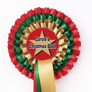 May include: A red, green and gold rosette with a red centre circle that says "Carole's Christmas Bash" in black text with a gold star. The rosette has a red, green and gold ribbon.